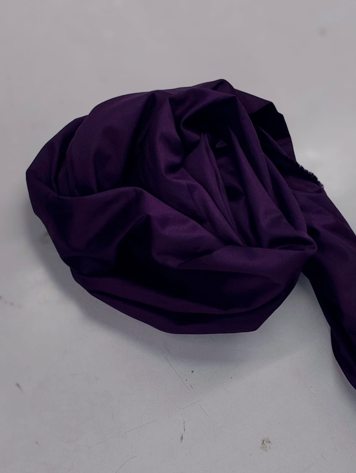 Close-up of folded purple cotton satin fabric from a Zinniars co-ord set.